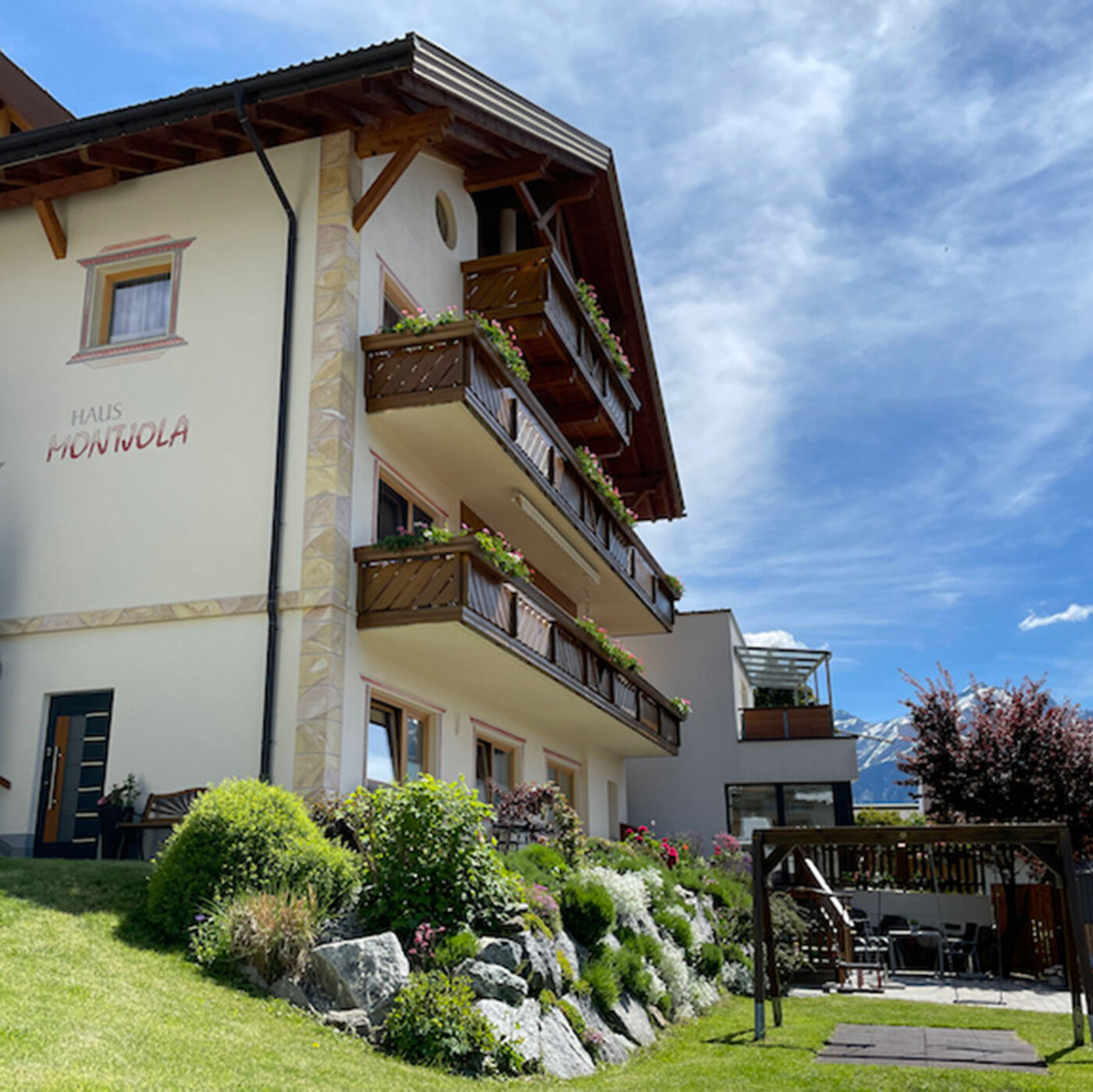 Haus Montjola in Serfaus mit Garten, Balkon und Blick auf die Tiroler Berge.