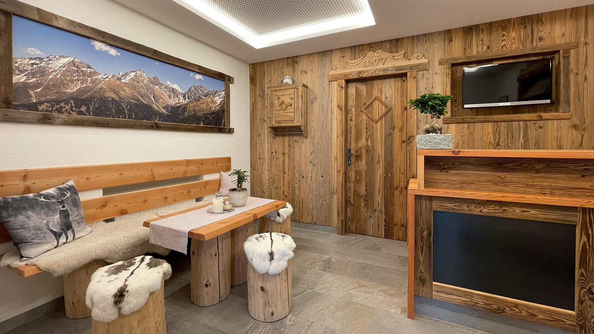 Gemütlicher Wohnraum im Haus Montjola Serfaus mit Holzdesign, Sitzgelegenheitund Kamin.