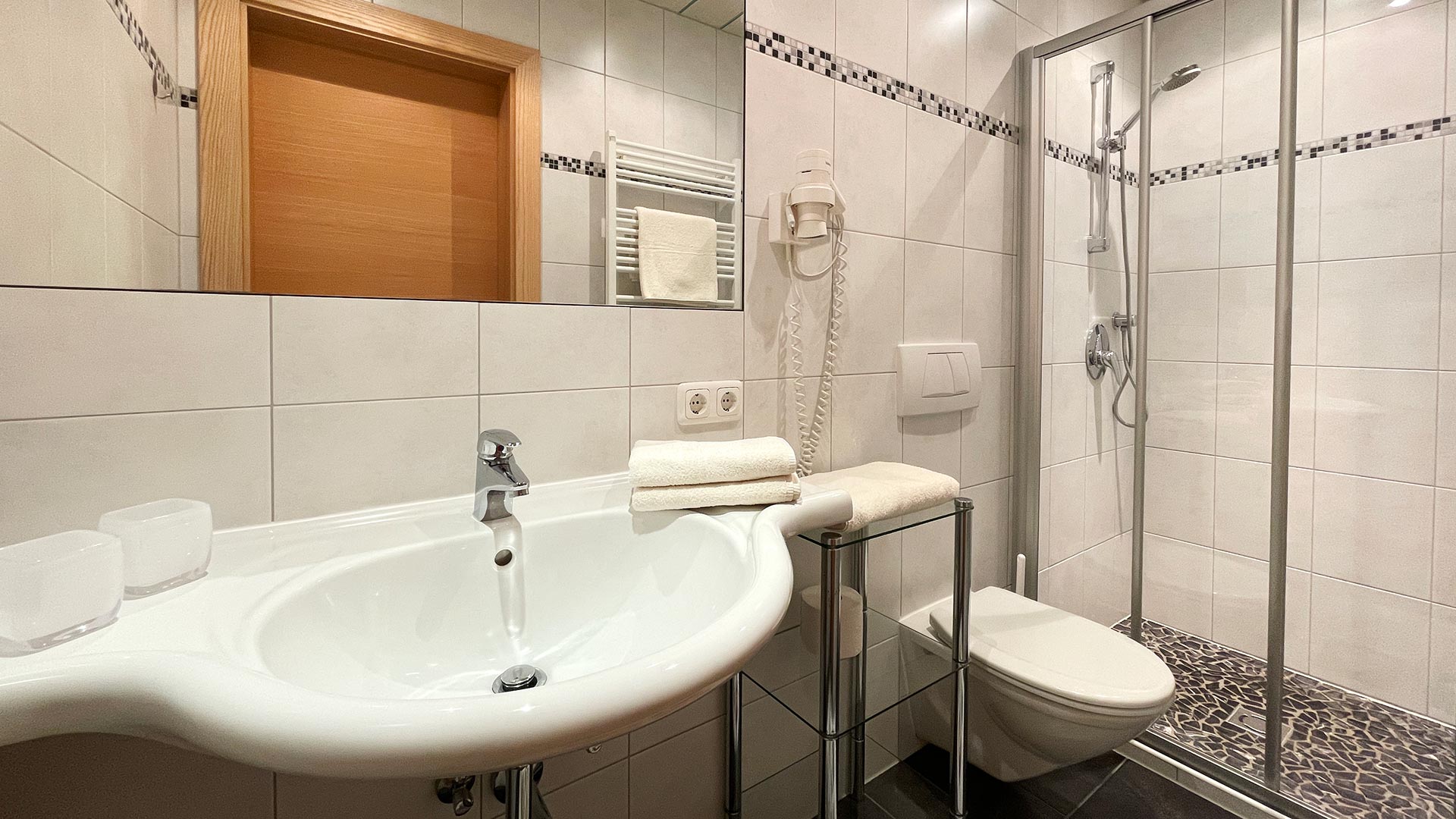 Badezimmer im Haus Montjola Serfaus mit Waschbecken, WC und Dusche.
